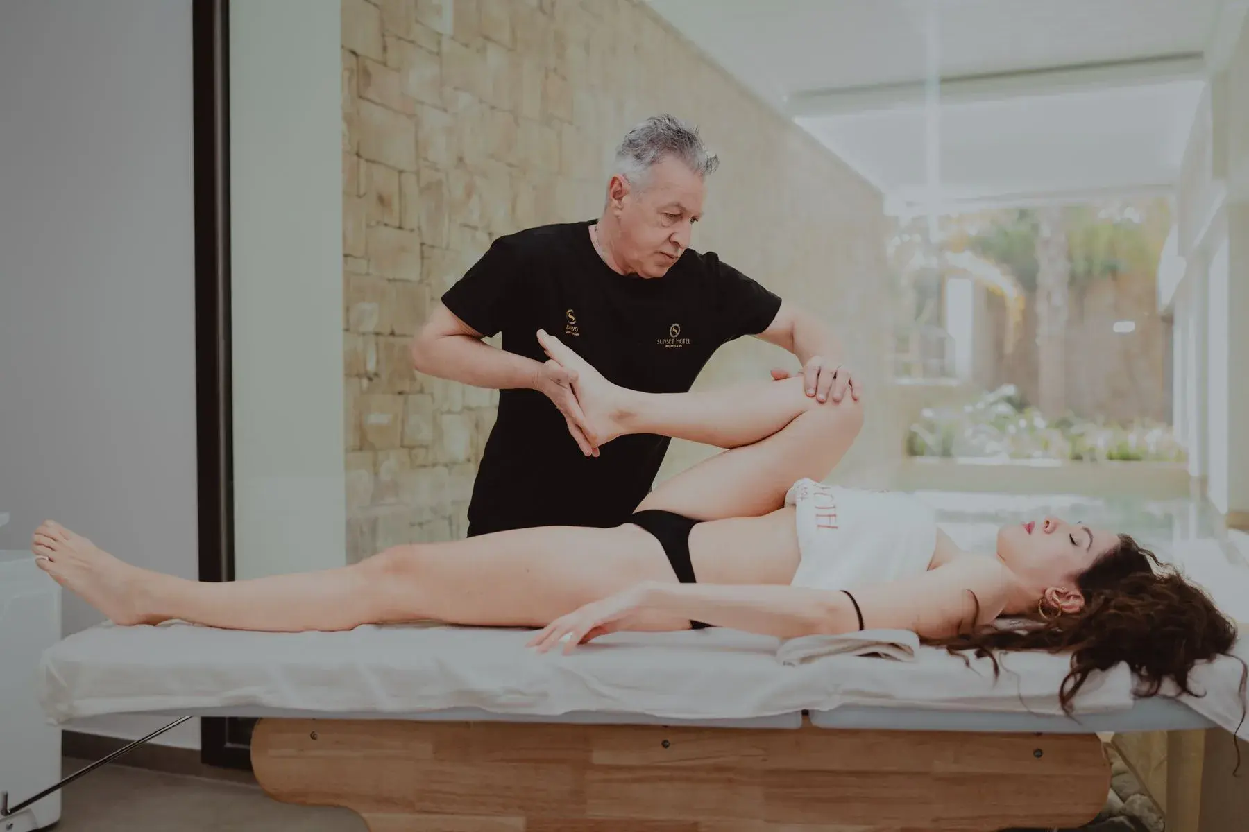 A physical therapist supporting a patient during rehabilitation